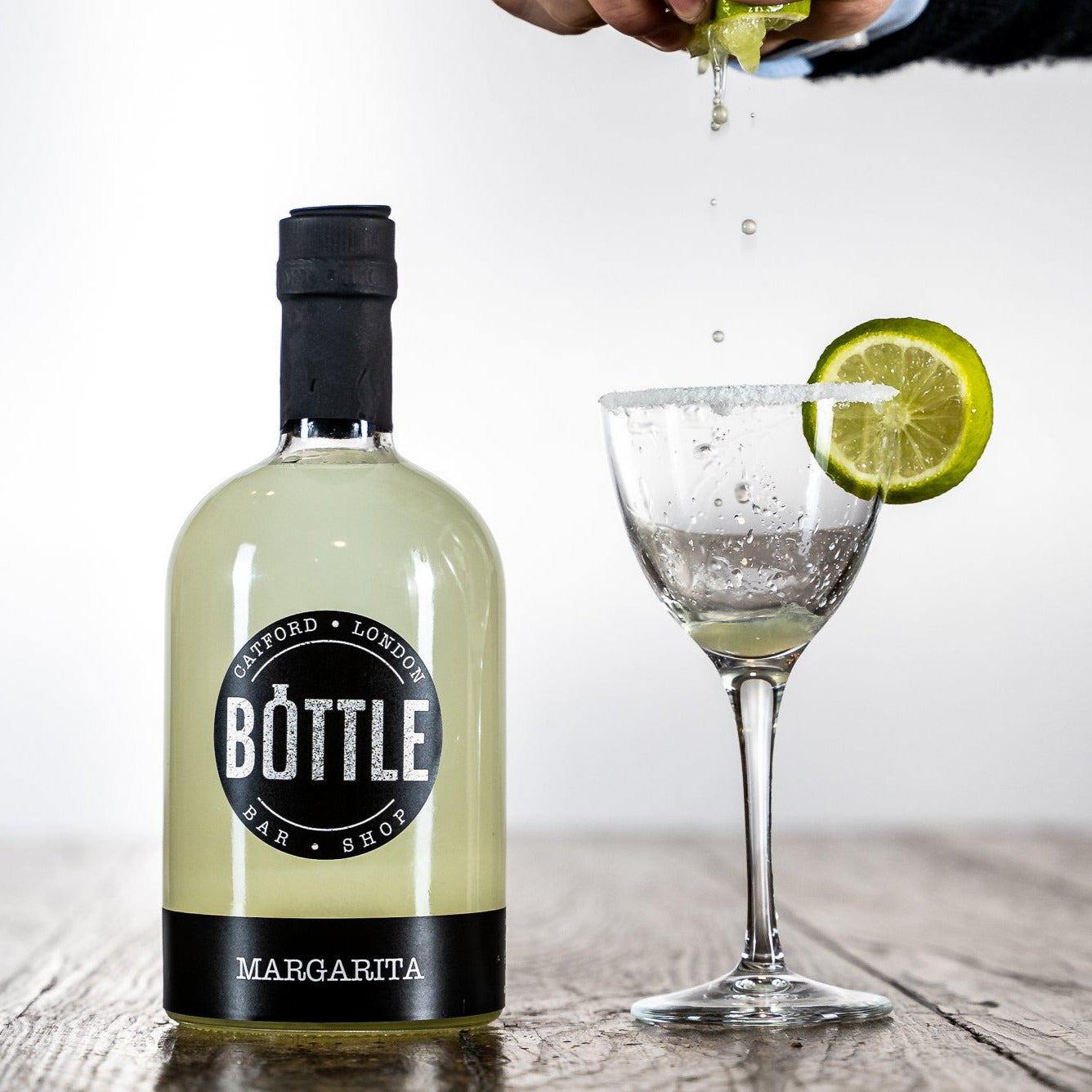 handmade-margarita-cocktail-with-salt-rim and lime garnish, made in the UK-, with a squeeze of lime