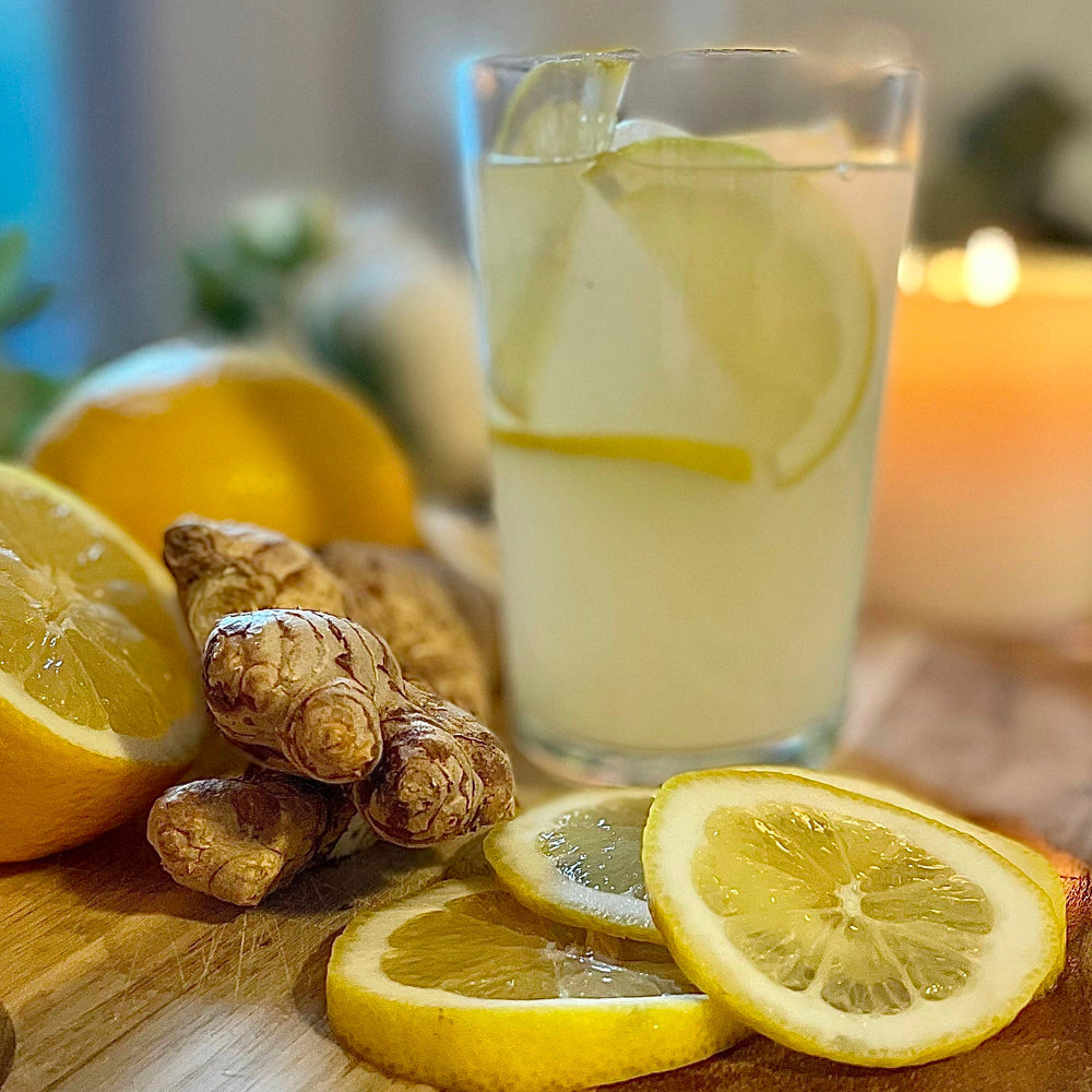 Ginger and lemon mocktail in a glass with fresh ginger and slices of lemon